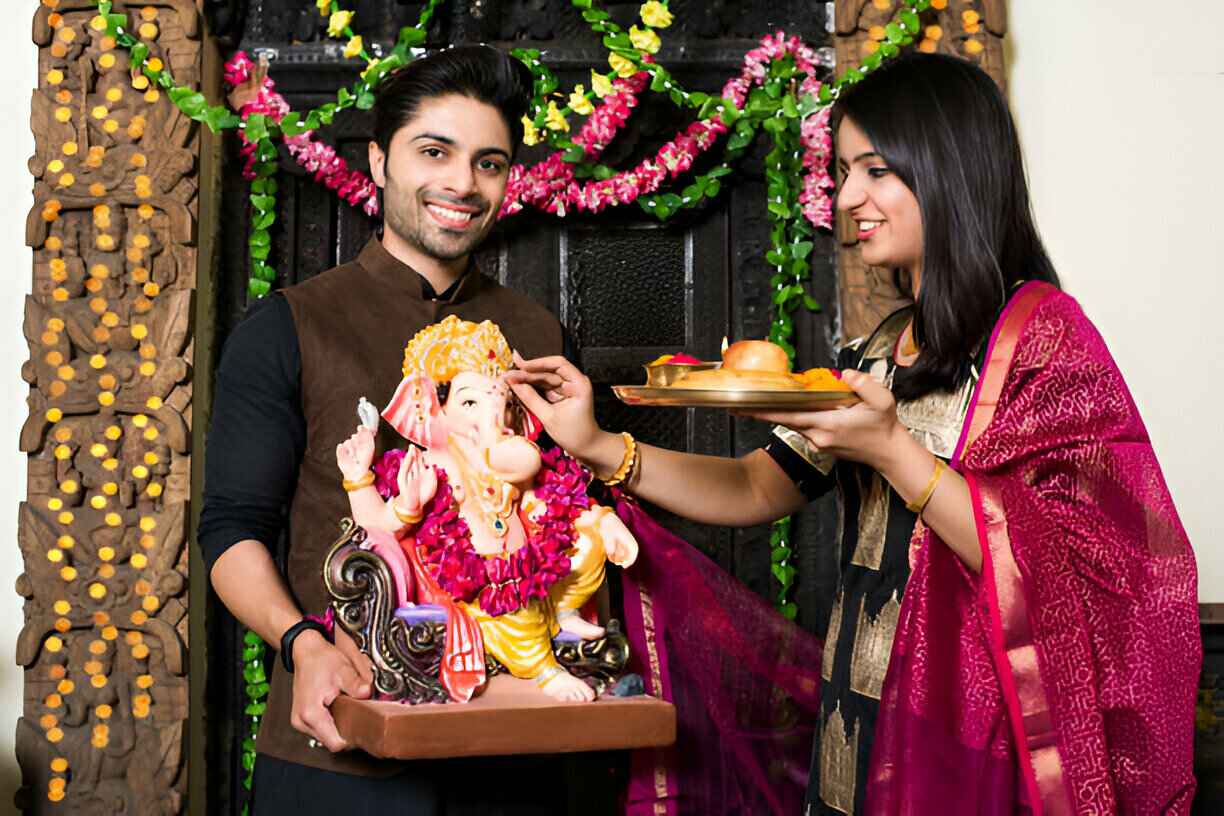 Pooja photoshoot of couple in traditional attire performing Ganesh archna